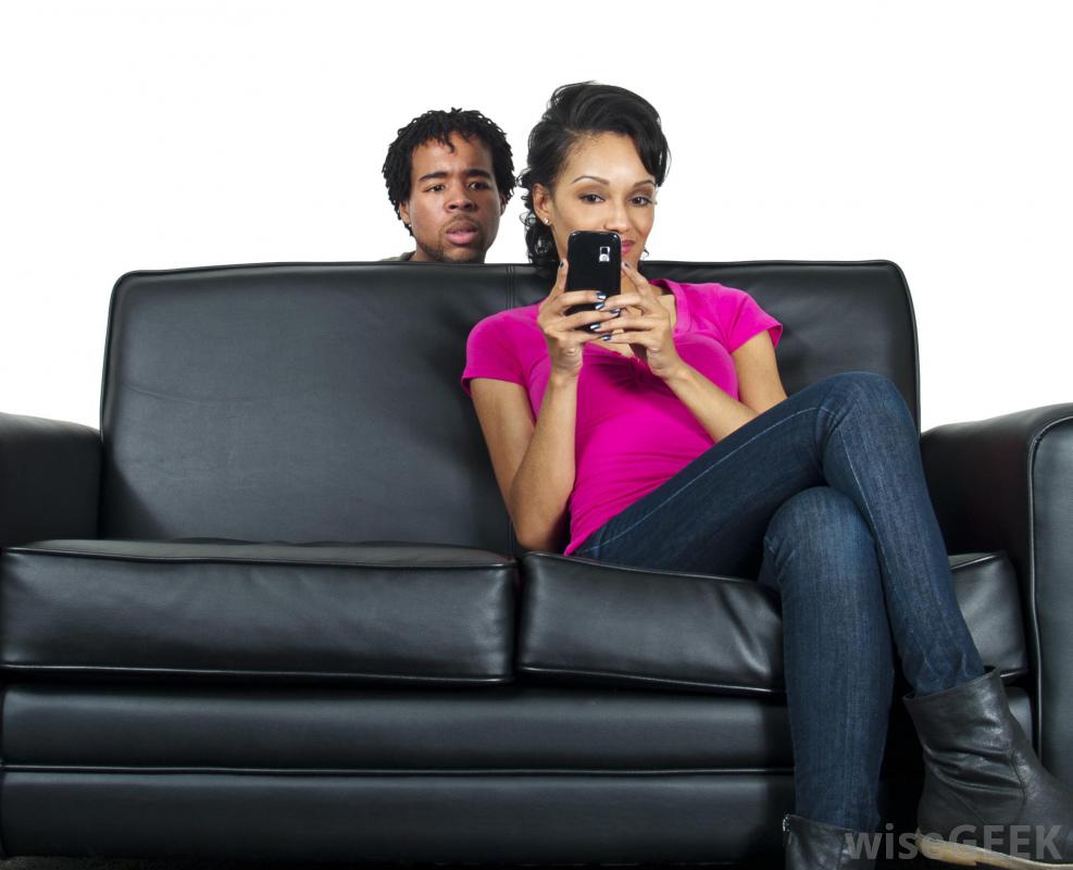 man-looking-over-the-couch-at-phone